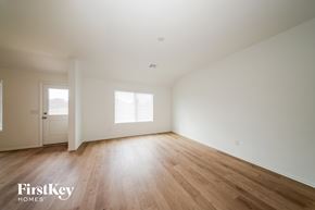 Tuttle house for rent - A spacious room with wooden flooring and two windows.