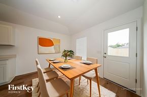 Tuttle house for rent - A dining room with a wooden table and chairs.