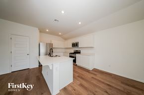 Tuttle house for rent - A kitchen with white cabinets and a wooden floor.