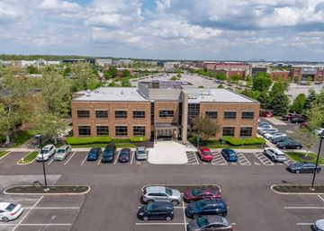 Columbus apartment for rent - A parking lot with cars and a building in the background.