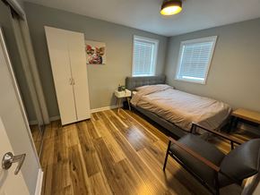 Louisville house for rent - A bedroom with a bed, chair, and a painting on the wall.