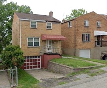 Pittsburgh house for rent - A red brick house with a white garage door.