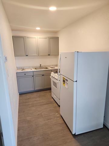 Olivehurst apartment for rent - A kitchen with a white fridge and cabinets.