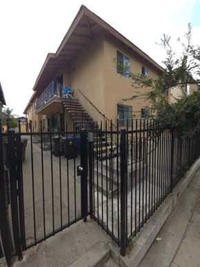 Los Angeles apartment for rent - A black iron fence in front of a tan building.