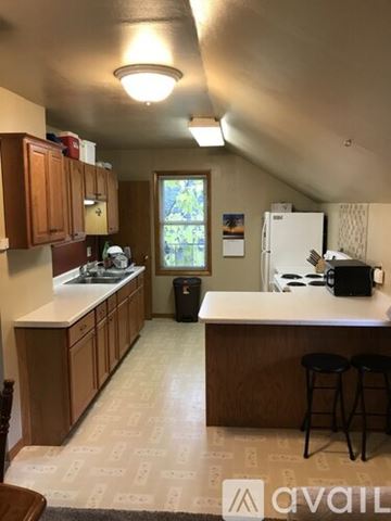 Bonduel apartment for rent - A kitchen with wooden cabinets and a white fridge.