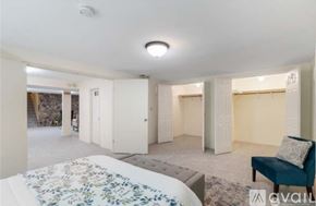 Auburn apartment for rent - A living room with a floral rug, a blue chair, and a white table.
