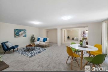 Auburn apartment for rent - A living room with a blue sofa, a white table, and a painting on the wall.