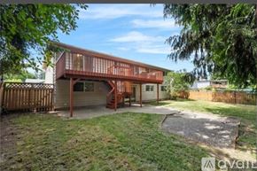 Auburn apartment for rent - A house with a wooden deck and a garage is surrounded by a fence and trees.