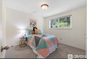 Auburn apartment for rent - A bedroom with a bed, a nightstand, and a window.