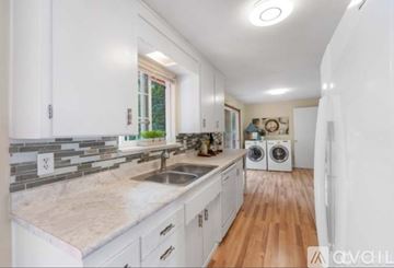 Auburn apartment for rent - A kitchen with white cabinets and a marble countertop.