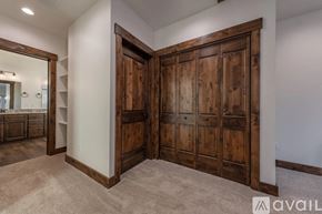 Victor house for rent - A large wooden door is open to a carpeted hallway.