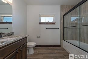Victor house for rent - A bathroom with a toilet, sink, and a window.