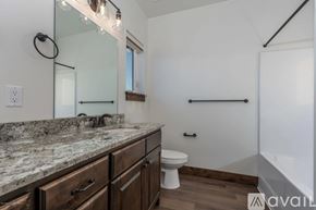 Victor house for rent - A bathroom with a marble countertop and wooden cabinets.