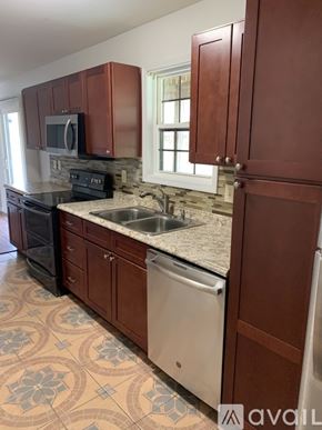 Cincinnati apartment for rent - A kitchen with brown cabinets and a white dishwasher.