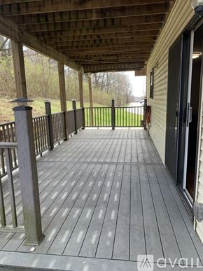 Cincinnati apartment for rent - A wooden deck with a railing and a view of a grassy area.