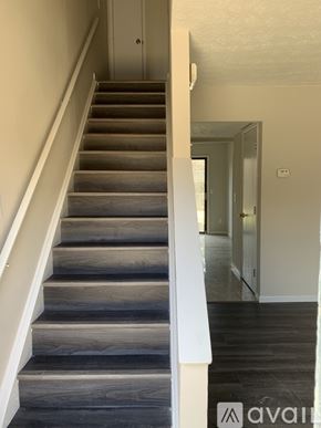 Cincinnati apartment for rent - A staircase with wooden steps and white railings.