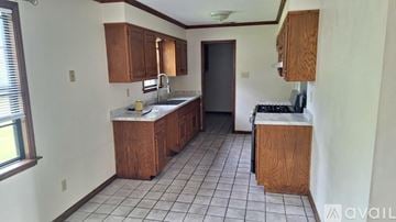Memphis house for rent - A kitchen with white tiles and wooden cabinets is available for rent.