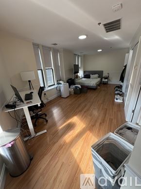 Boston apartment for rent - A room with a bed, desk, and trash can.