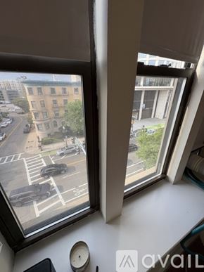 Boston apartment for rent - Two windows looking out at a street with cars and buildings.