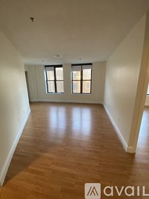 Boston apartment for rent - A room with wooden floors and two windows.