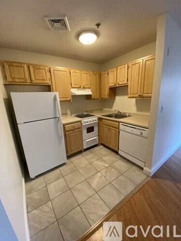 Boston apartment for rent - A kitchen with wooden cabinets and white appliances.
