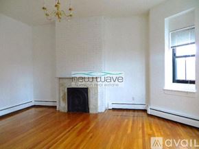 Boston apartment for rent - A room with a fireplace and wooden floors is available for rent.