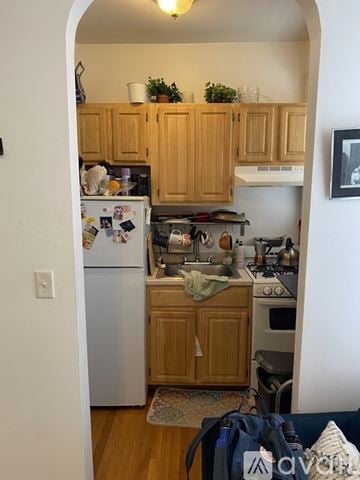 Boston apartment for rent - A kitchen with wooden cabinets and a white refrigerator.