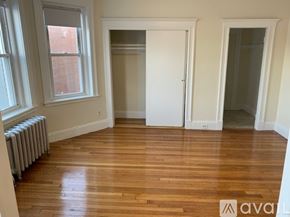 Boston apartment for rent - A room with wooden floors and a window with a radiator beneath it.
