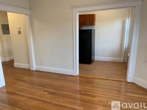 Boston apartment for rent - A room with wooden floors and a black refrigerator.