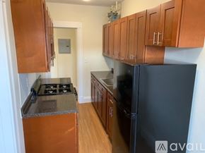 Boston apartment for rent - A kitchen with wooden cabinets and a black refrigerator.