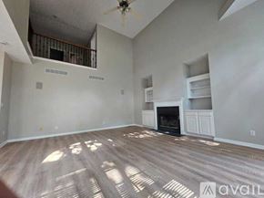 Louisville house for rent - A living room with a fireplace and a ceiling fan.