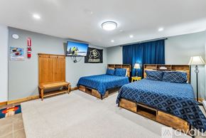 Breckenridge house for rent - A bedroom with two beds and a TV mounted on the wall.