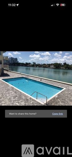 Miami Beach condo for rent - A rectangular blue pool with a metal railing on the side.