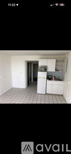 Miami Beach condo for rent - A kitchen with white cabinets and a black refrigerator.