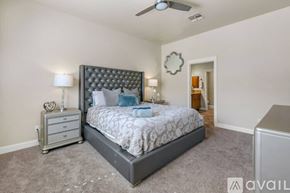 Lake Havasu City house for rent - A bedroom with a large bed and a ceiling fan.