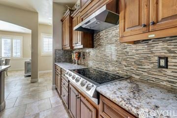 Lake Havasu City house for rent - A kitchen with wooden cabinets and a granite countertop.