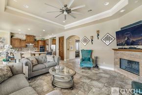 Lake Havasu City house for rent - A living room with a grey couch, a blue chair, and a fireplace.