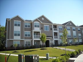 Mount Royal apartment for rent - an apartment building with a green lawn and trees in front of it