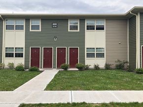 North Brunswick apartment for rent - a building with three red doors and a grass yard