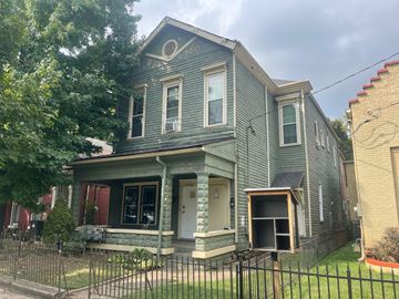 Louisville apartment for rent - A grey house with a black fence in front.