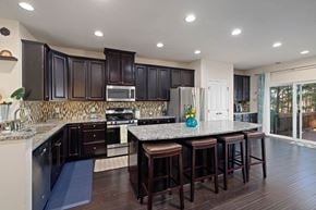 Cary house for rent - A kitchen with dark brown cabinets and a granite countertop.