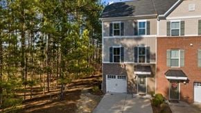 Cary house for rent - A modern two-story house with a garage is surrounded by trees.