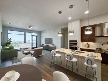 Dallas apartment for rent - A modern kitchen with a bar area and a dining table.