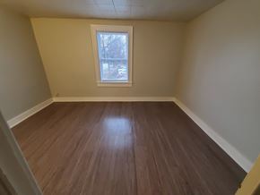 Lima apartment for rent - Empty room with wooden floor and a window.