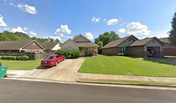 Tupelo house for rent - A red car is parked in front of a house.