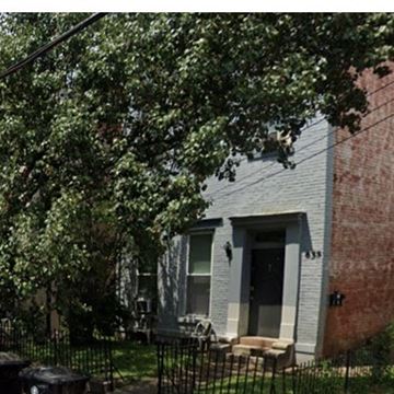 Louisville apartment for rent - A house with a black gate and a tree in front.
