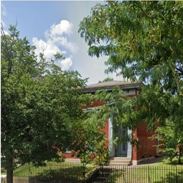 Louisville apartment for rent - A red brick house with a white door and a tree in front.