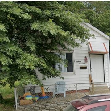 Louisville house for rent - A white house with a red roof and a tree in front.