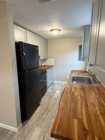 St. Augustine house for rent - A black refrigerator is in a kitchen with a wooden counter top.