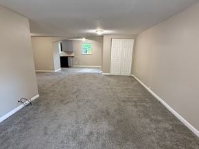 St. Augustine house for rent - A spacious room with a carpeted floor and a white door.